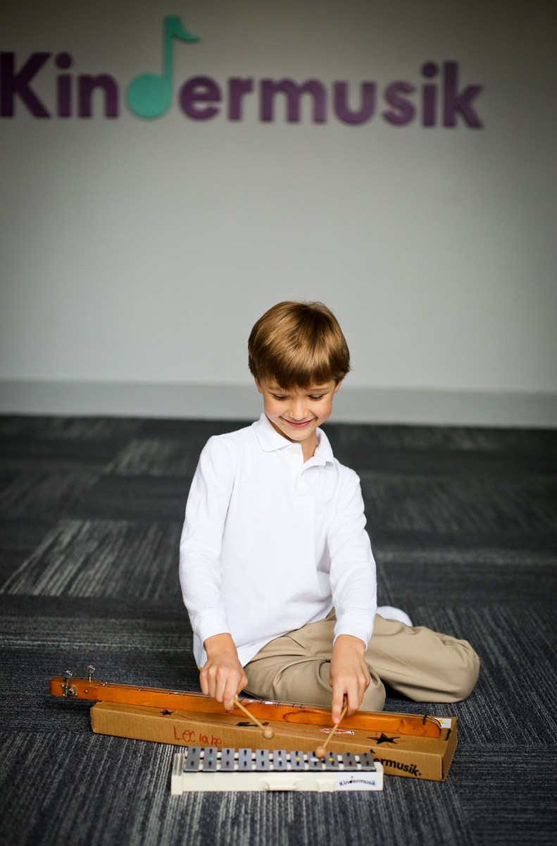 Young boy playing dulcimer and glockenspiel. What to expect in music lessons for kids.