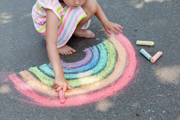  A girl playing outside with chalk during a level 5 Kindermusik class.