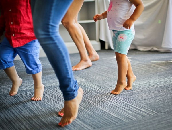 Grownup and child feet dancing on toes to the beat during music classes for kids.