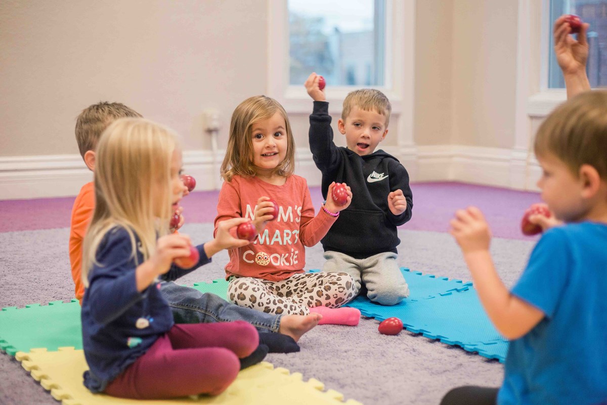 A group of kids playing with egg shakers in their level 2 Kindermusik class.