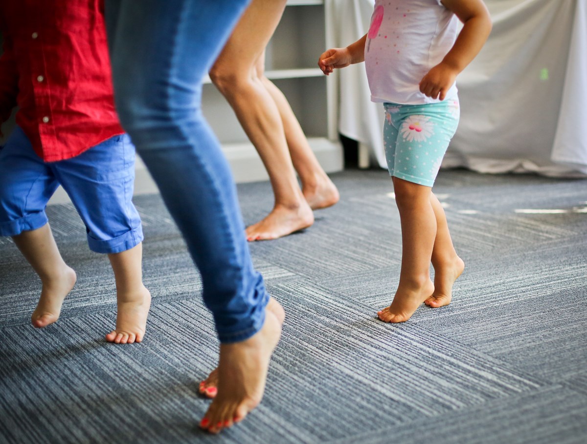 Grownups and children dance on their toes during a Kindermusik class.