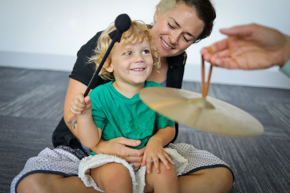 Two year old playing cymbal. What you’ll learn in a music class for two year olds.