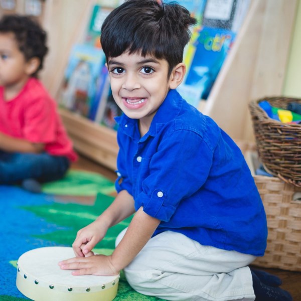 Preschooler plays a drum during music classes for 4-6-year-olds.