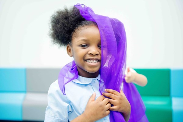 Girl playing with a scarf in her level 5 Kindermusik class.