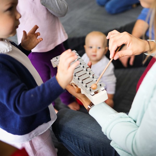 Children listen to and play the glockenspiel in music classes for 0-7-year-olds.