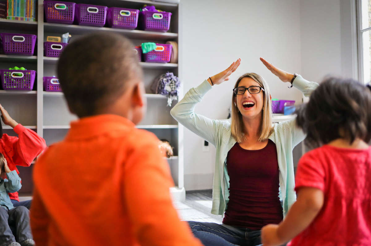 A female teacher leads a Kindermusik class. Teaching scholarships are now available for military spouses. 